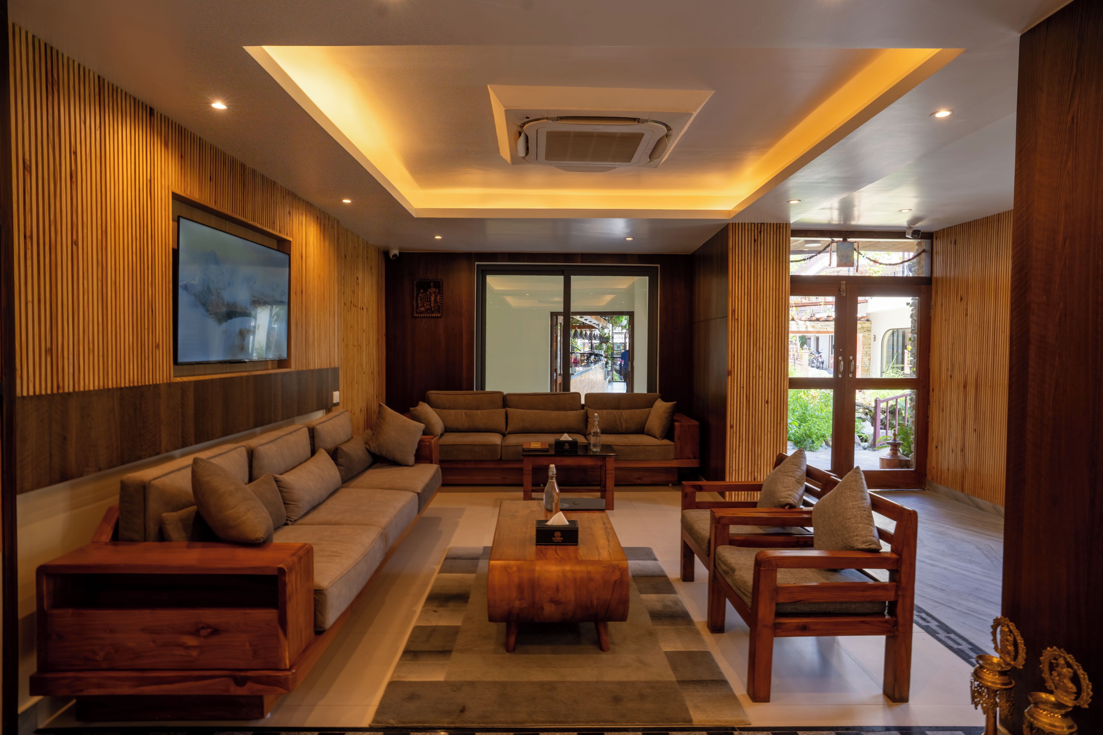 A modern living room with a sectional sofa, a coffee table, and a TV mounted on the wall.