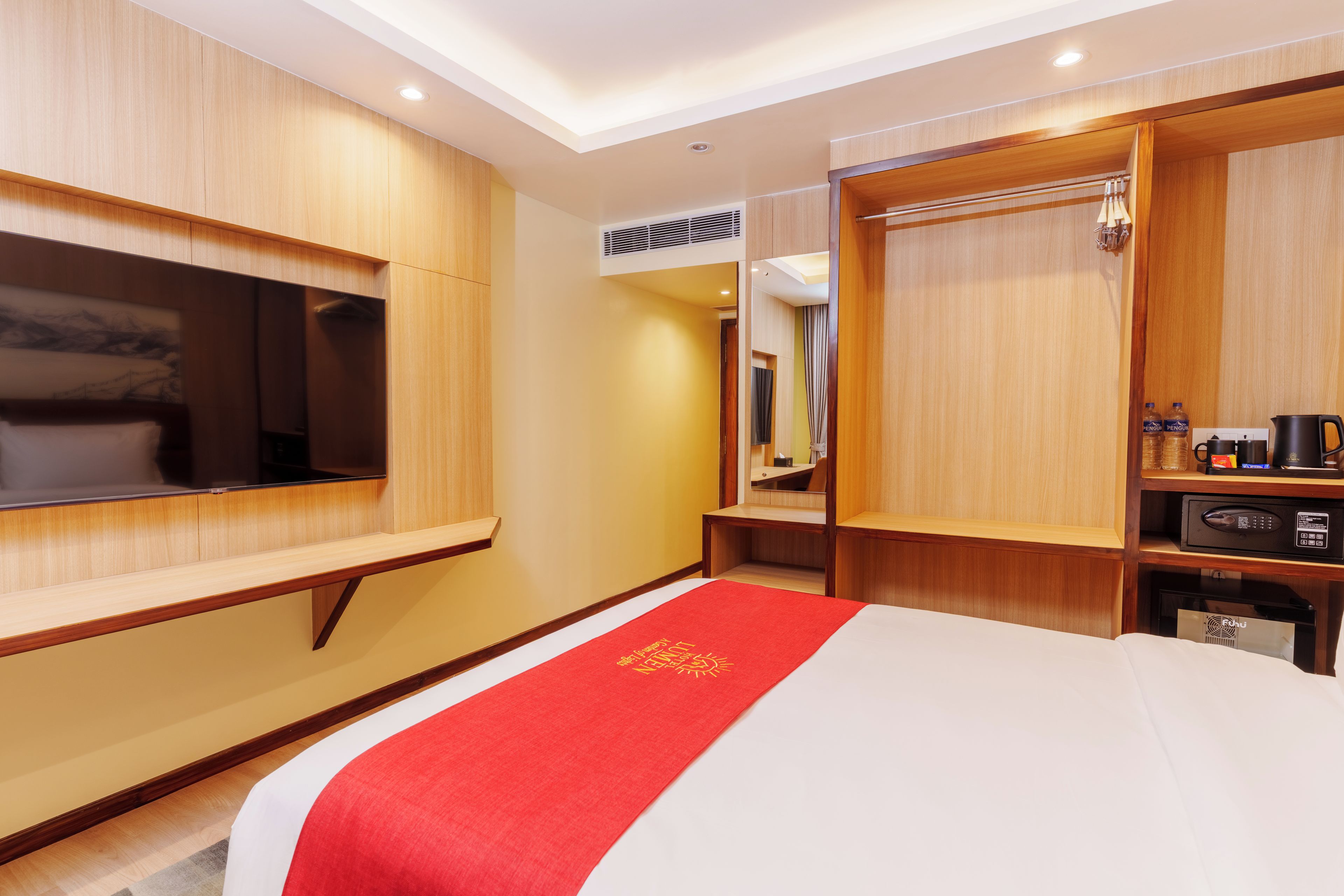 Una habitación de hotel con cama, televisión, escritorio y armario.
