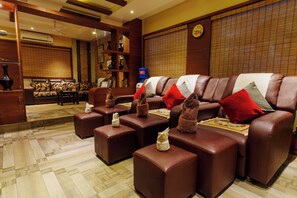 A hotel lobby with leather sofas, a reception desk, and a water dispenser.