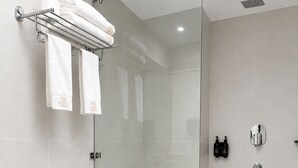 A modern bathroom with a glass-enclosed shower, a white toilet, and a black countertop. - Hotel Lumen - A Garden of Lights (Pokhara)