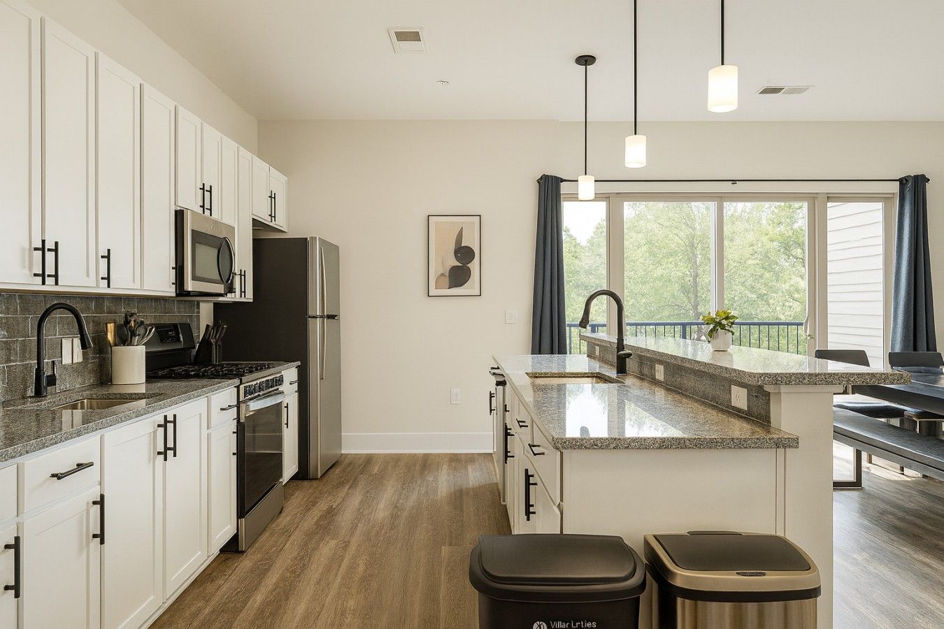 A modern kitchen with white cabinets, a stainless steel refrigerator, a microwave, and a granite countertop.