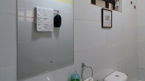 Ein Badezimmer mit Waschbecken, Toilette und Spiegel über dem Waschbecken.
