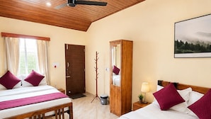 A hotel room with two beds, a wooden ceiling, a large window, and a painting on the wall. - Venkataramana KV (Mekeri)