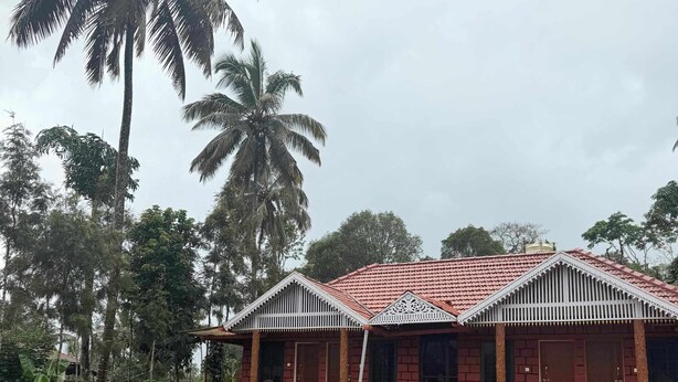 A two-story building with a red-tiled roof, a covered porch, and a well-maintained lawn. - Venkataramana KV (Mekeri)