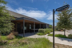 A building with a covered entrance and a sign that reads 'JUNCTION PRIME'. - 🌊 New - Lakeview at LBJ - Private Pool, Hot Tub, Sleeps 14 ✨ (Kingsland)