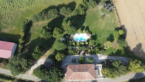 An aerial view of a property with a swimming pool, a red-roofed building, and a road. - Gîte 'Maison Cazac Manon' with Mountain View and Wi-Fi (Cazac)