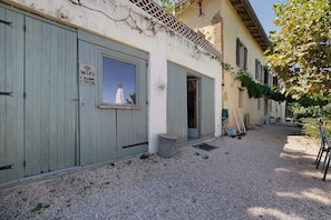 A building with a sign indicating WiFi availability, a window with a view, and a gravel driveway. - Holiday Home 'Maison Cazac Marrakech' with Mountain View and Wi-Fi (Cazac)