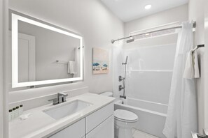 A modern bathroom with a large mirror, two sinks, a toilet, and a shower. - Blue Horizon 2 Blocks to Ocean Pets (North Myrtle Beach)
