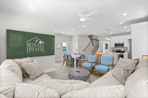 A spacious living room with a sofa, chairs, a dining table, and a kitchen area. - Blue Horizon 2 Blocks to Ocean Pets (North Myrtle Beach)