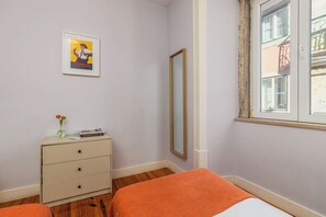 A bedroom with a bed, a dresser, a mirror, and a window. - Vintage-Chic Apartment in the City Center, Chiado (Lisboa)