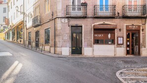 Et gadesyn med en bygning, der har en restaurant ved navn 'DUQUE' og en anden restaurant med navnet 'COZINHA PORTUGUESA E MEDITERRÂNICA'.