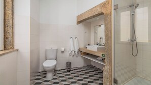 Et moderne badeværelse med toilet, vask og brusebad.