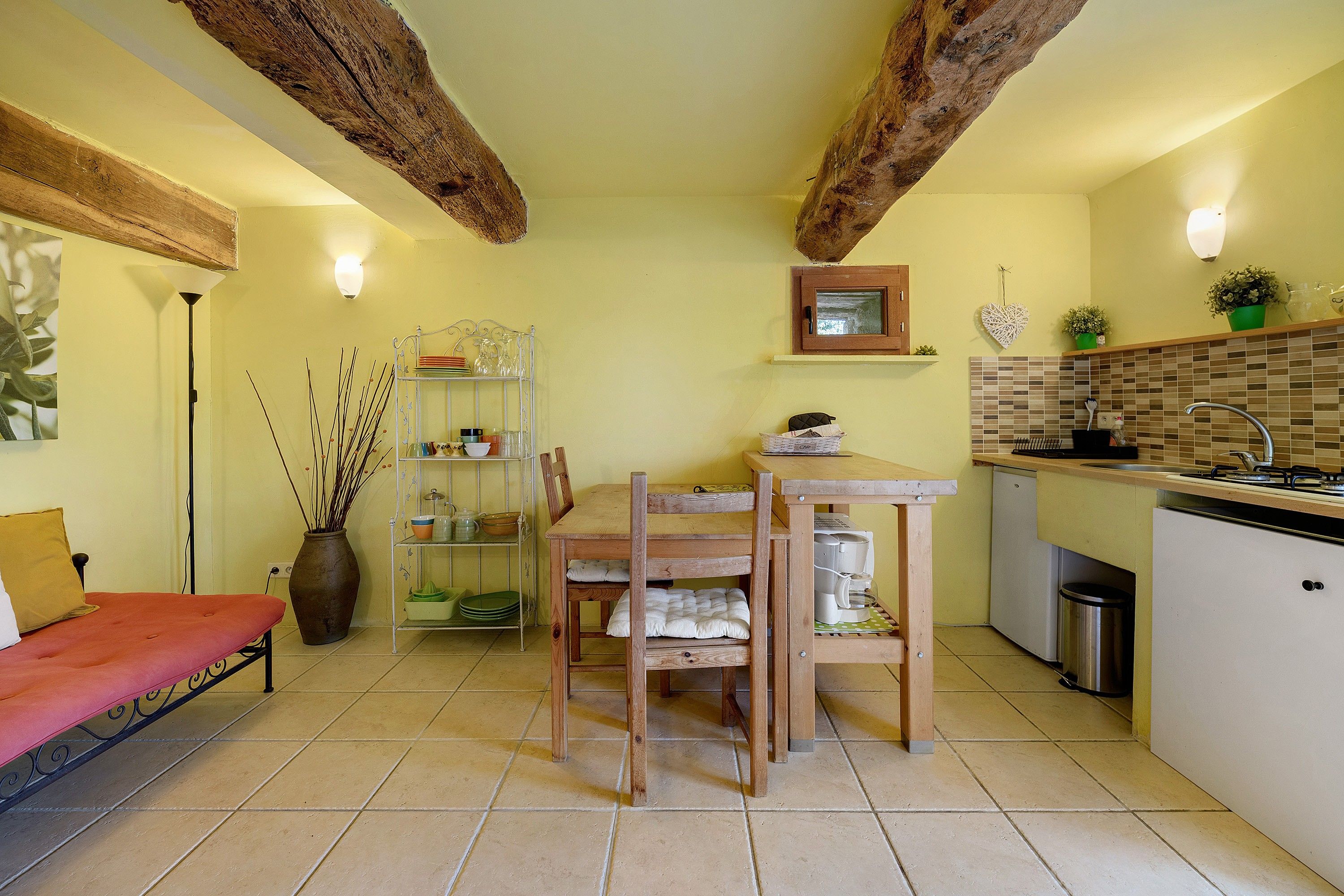 A compact kitchen with a dining table, a built-in oven, and a sink.