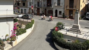 A street view with multi-story buildings, a roundabout, and a statue. - La Fontanella - Authentic Sicilan Retreat (Ciminna)