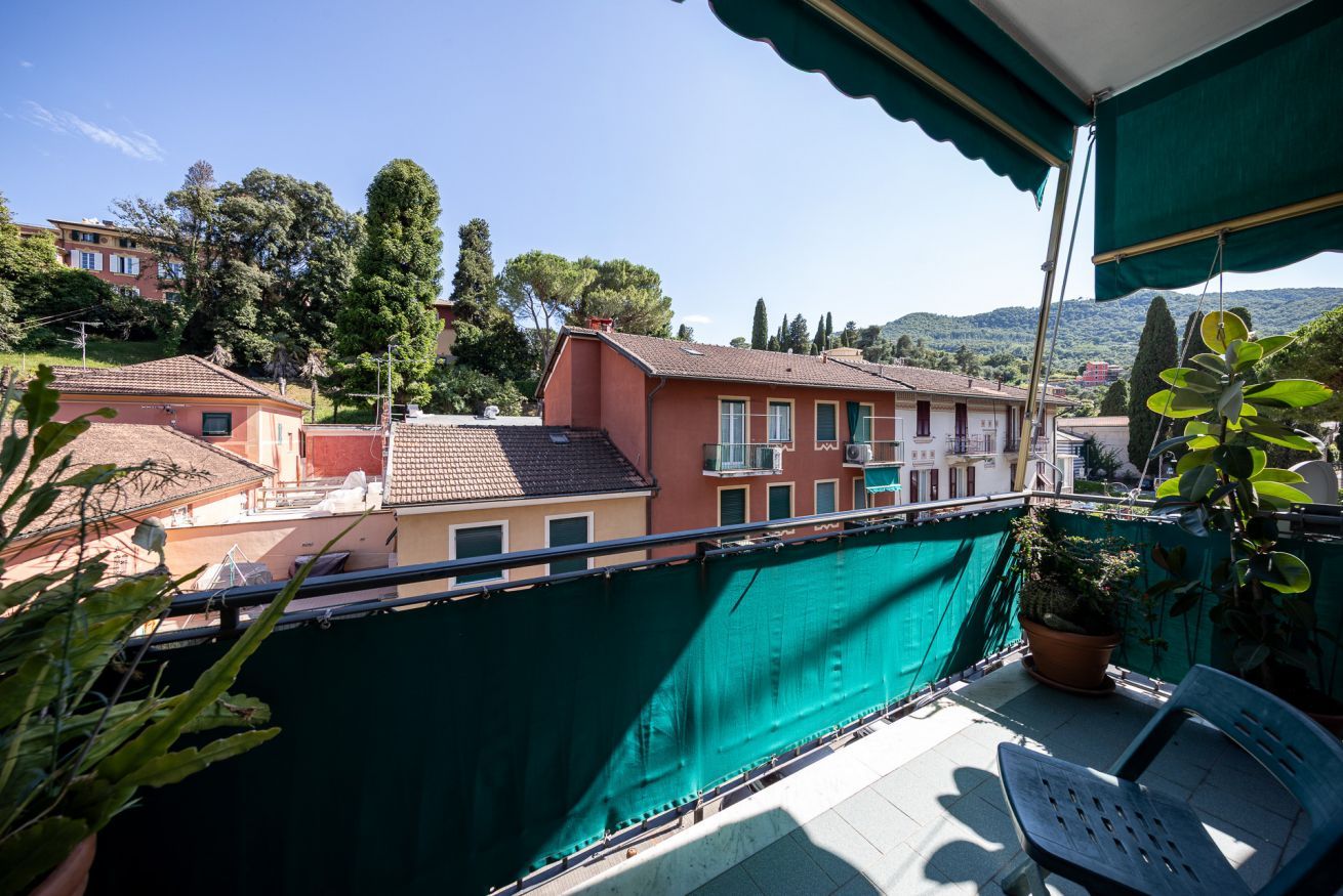 Un balcon agrémenté d’un treillis végétal, d’une plante en pot et d’une chaise.