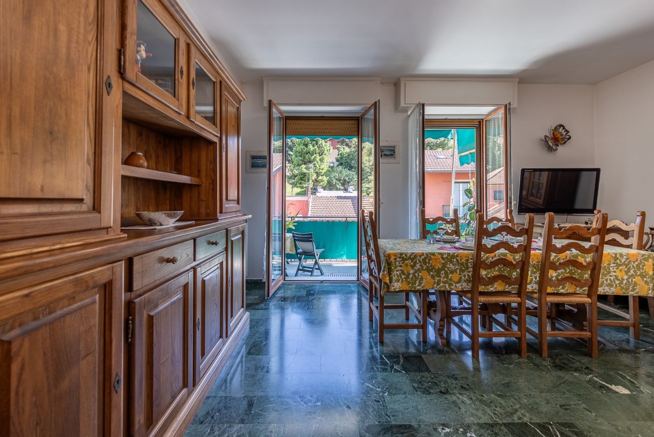 Un coin repas avec une table et des chaises, un meuble en bois et un téléviseur fixé au mur.