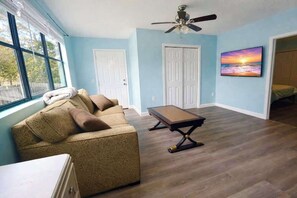 Quarto com sofá, mesa e ventilador de teto.