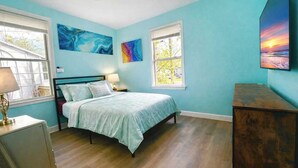 A bedroom with a bed, two windows, a dresser, and artwork on the walls. - The Big Blue Mesmerizing Mirror Home- 6 Mins to DT (Jacksonville)