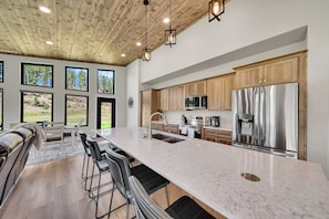 A spacious kitchen with a large island, stainless steel appliances, and wooden cabinets. - Experience the vibe of Hill City, South Dakota (Hill  City)