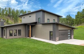 A modern two-story house with a garage, large windows, and a well-maintained lawn. - Experience the vibe of Hill City, South Dakota (Hill  City)