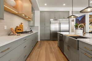 A modern kitchen with grey cabinets, stainless steel appliances, and a wooden countertop. - Red Rock Isle: Private Pool + Hot Tub! Games! (Washington)