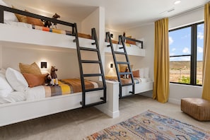 A room with bunk beds, a window with a view, and a rug. - Red Rock Isle: Private Pool + Hot Tub! Games! (Washington)
