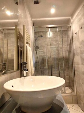 A modern bathroom with a large oval sink, a glass shower enclosure, and a mirror. - IL VECCHIO BORGO RELAIS (Como)