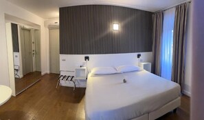 A hotel room with a large bed, bedside tables, a mirror, and a wardrobe. - IL VECCHIO BORGO RELAIS (Como)
