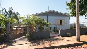 Una casa residencial con entrada protegida por una reja, un pequeño porche y un camino de hormigón.