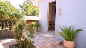 Una propiedad residencial con un patio empedrado, plantas en macetas y una valla de madera.