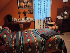 Ein Schlafzimmer mit Bett, Schreibtisch, Stuhl und Kommode.