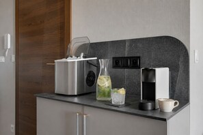 A modern kitchen with a built-in coffee maker, a kettle, and a glass pitcher on the counter. - Bubble Love Suites - Jacuzzi & Parking  (Gdańsk)