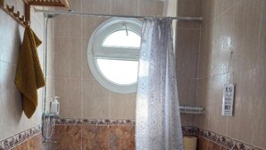 Un baño con ducha, inodoro y lavamanos.