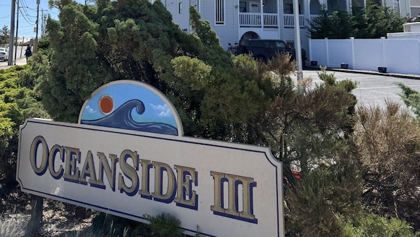 Ein Gebäude mit einem Schild, auf dem 'OCEANSIDE III' steht, und einer amerikanischen Flagge.