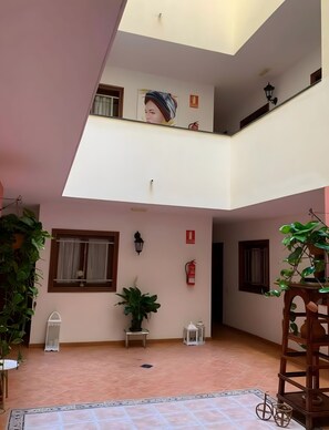 Un interior amplio con techo alto, un balcón y varias ventanas.