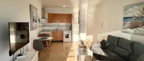 A modern apartment with a kitchen, dining area, and living room.