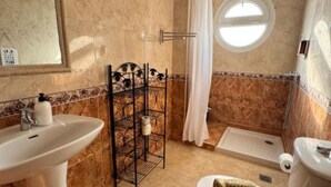 Et badeværelse med vask, toilet og badekar.