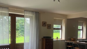 Un comedor con mesa, sillas y vistas al exterior.