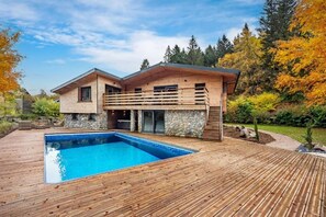 A modern two-story house with a wooden deck and a swimming pool. - La Perle Verte: A luxurious retreat with a pool, spa, and sauna (Gérardmer)