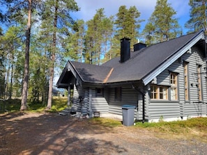 A log cabin with a chimney, a porch, and a trash bin. - Honkaruka | Homelike 1BR Apt with Private Sauna (Ruka)
