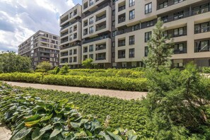A multi-story residential building with balconies, a paved walkway, and well-maintained greenery. - A Practical Studio Flat with a Balcony | Close to the City Centre (Kraków)