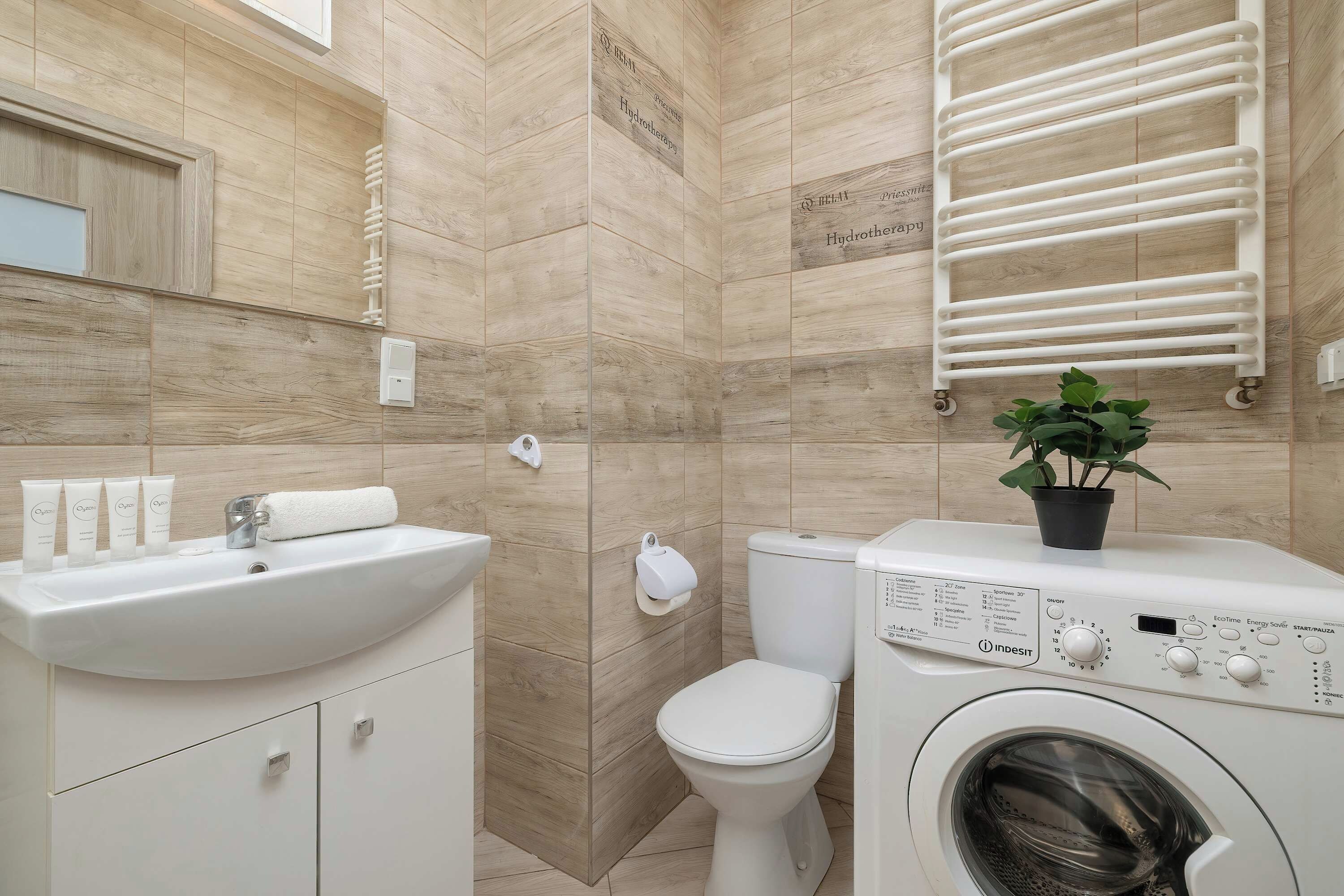 A modern bathroom with a sink, toilet, and a built-in washing machine.