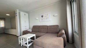 A living room with a sofa, a small table, a wardrobe, and a framed picture on the wall. - Pleasant 2-bedroom apartment with AC in charming CN (CN)