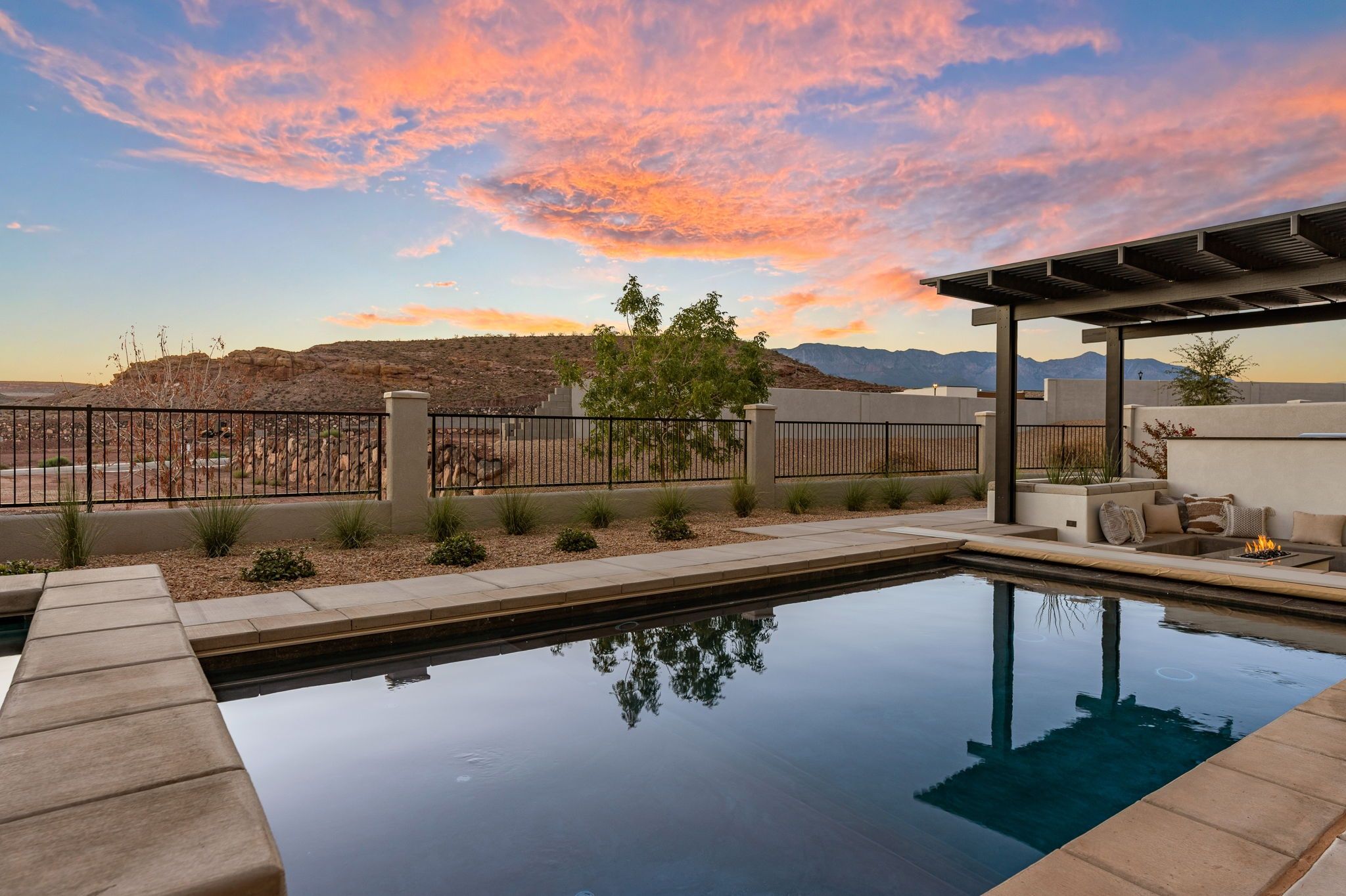 Una piscina con vistas a montañas y al atardecer.