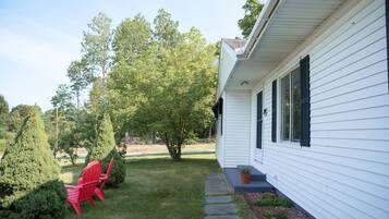 A residential property with a white exterior, a stone pathway, and a well-maintained lawn.