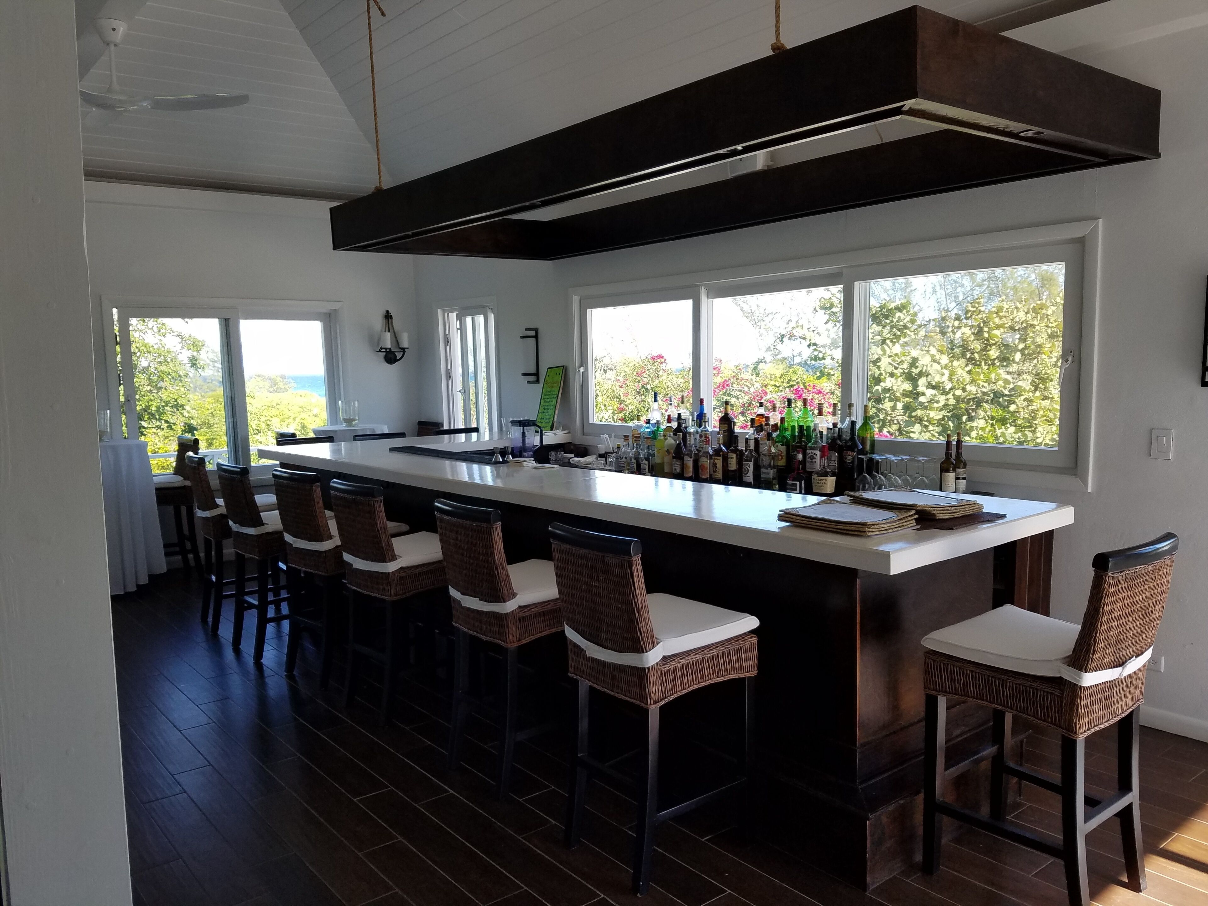 Una cocina moderna con barra, ventanas amplias y vistas al exterior.