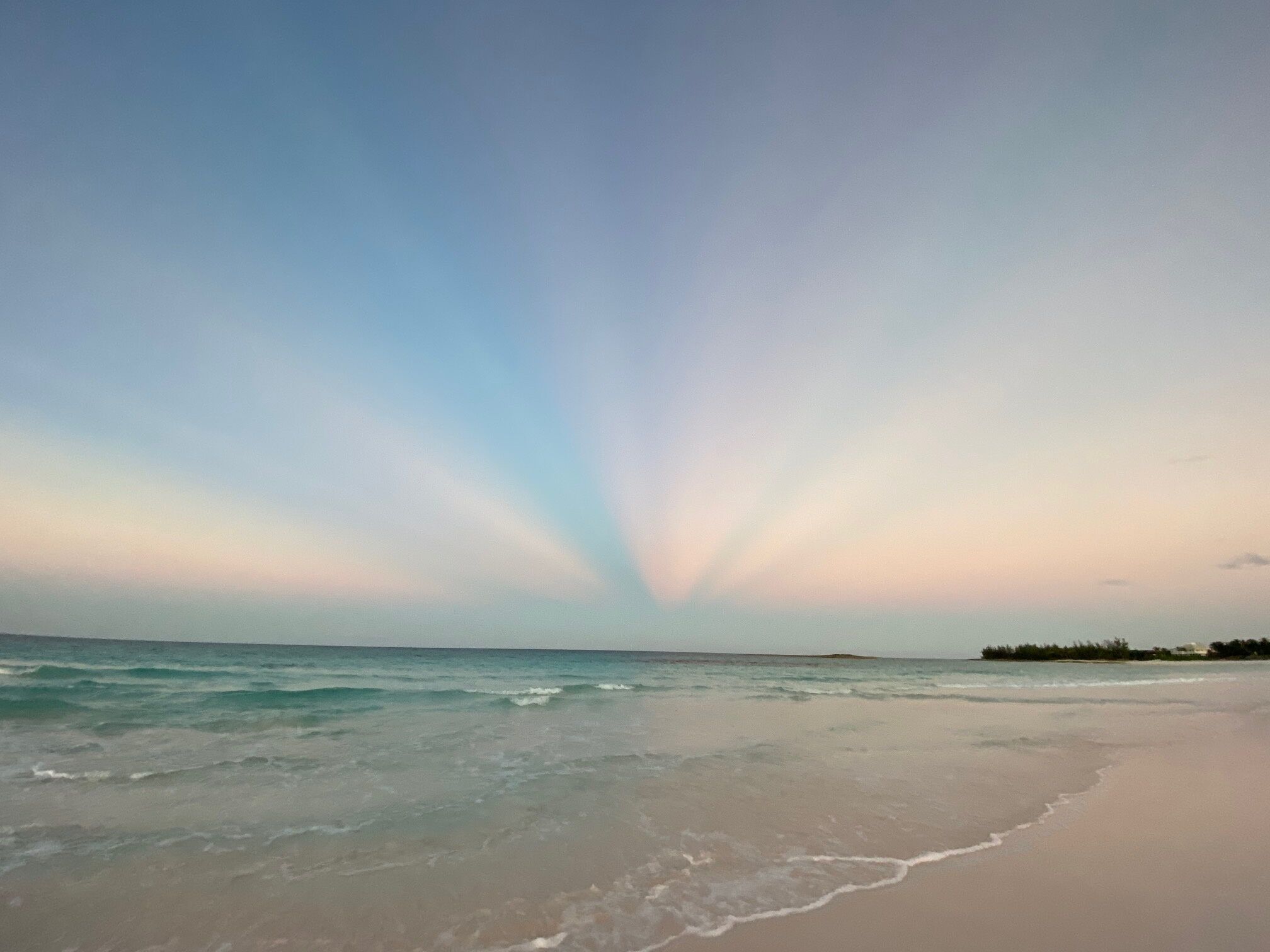 A beach with a calm sea and a clear sky.