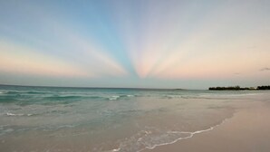 Ein Strand mit ruhiger See und blauem Himmel.