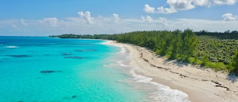 Una playa con aguas turquesas cristalinas y una orilla arenosa.