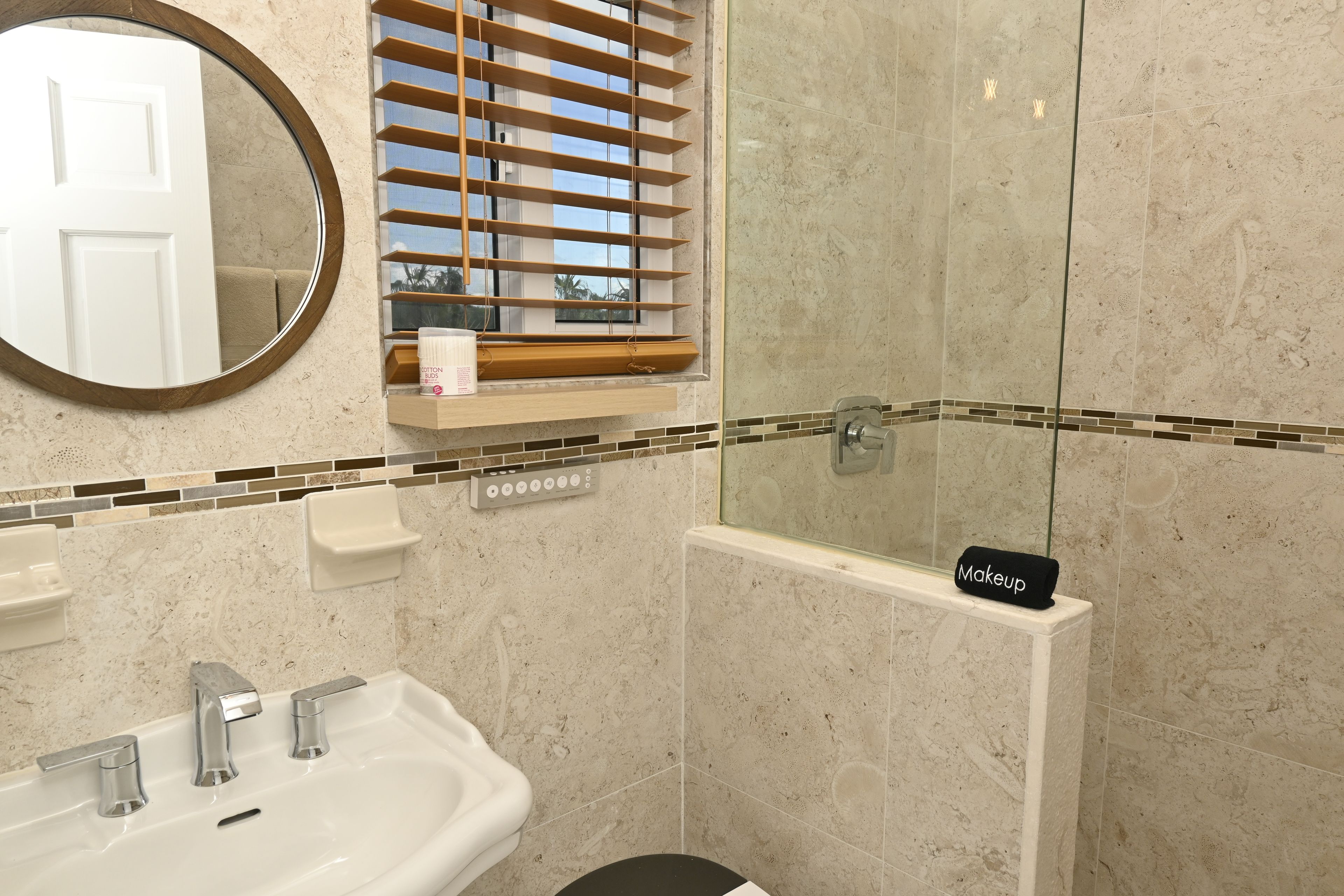 Une salle de bain équipée d’un lavabo, d’un miroir et d’un espace douche.